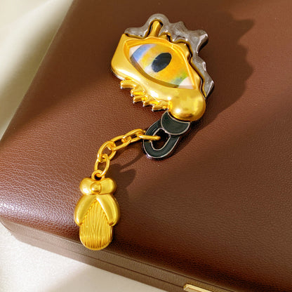 Golden Eye Pin Made Of Resin Featuring Artificial Diamond Inlay