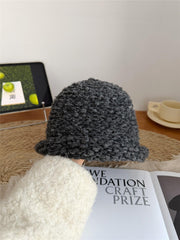 Gorro de pescador de punto, de color gris oscuro, con borde enrollado y diseño de colores combinados.